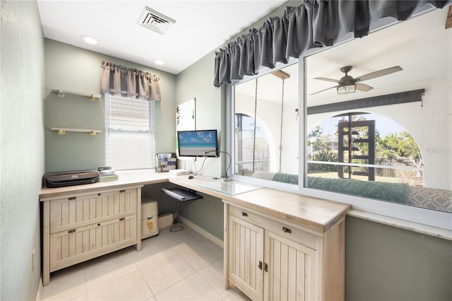 office space with ceiling fan, built in desk, and light tile patterned floors