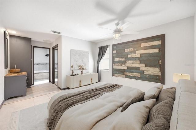 tiled bedroom with ensuite bathroom and ceiling fan