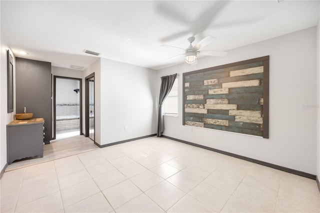 empty room featuring ceiling fan and light tile patterned flooring