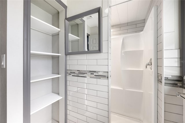 bathroom with tile walls and walk in shower