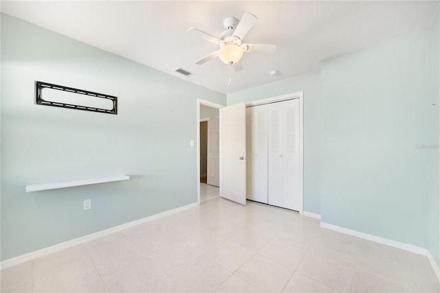 unfurnished bedroom with ceiling fan and a closet