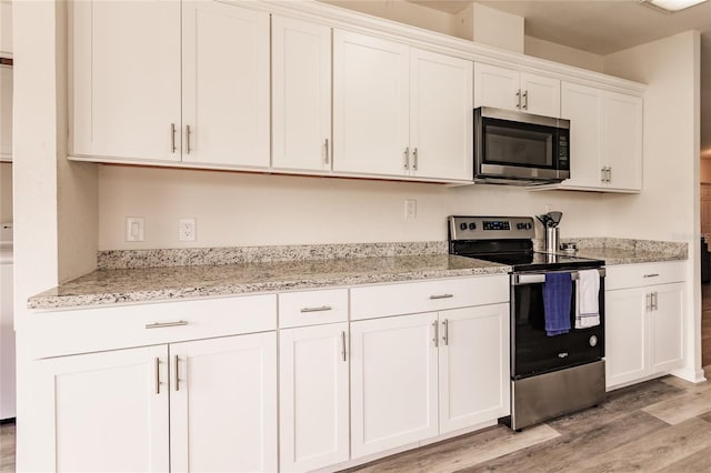 kitchen featuring light hardwood / wood-style floors, light stone counters, white cabinetry, and stainless steel appliances