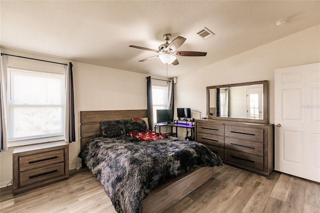 bedroom featuring ceiling fan, light hardwood / wood-style floors, and vaulted ceiling