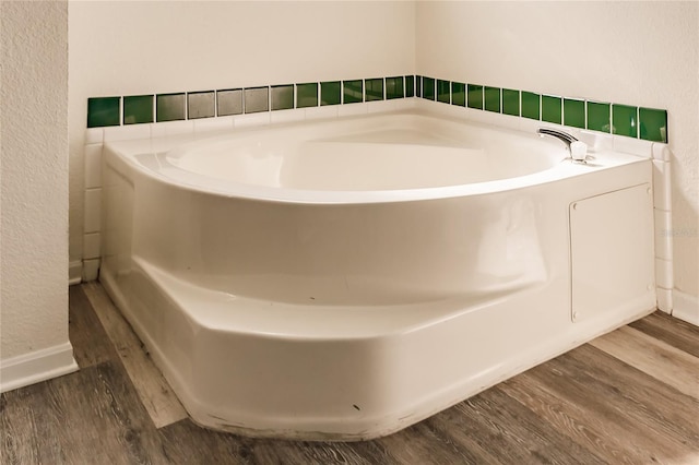 bathroom with a bath and hardwood / wood-style flooring