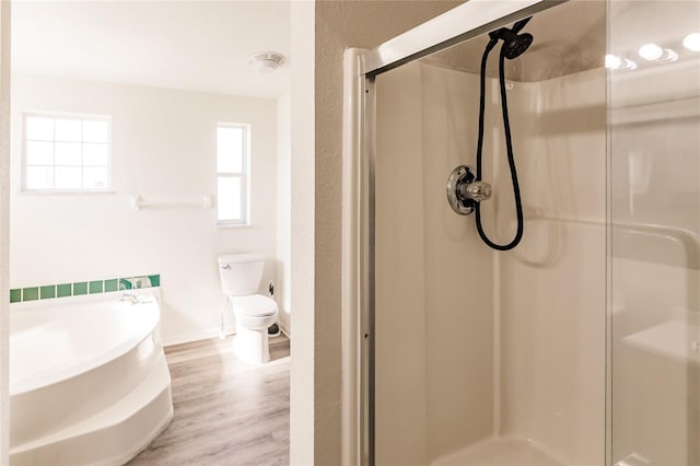 bathroom featuring wood-type flooring, toilet, and a shower with door