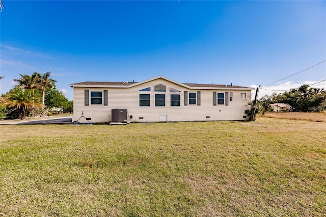 rear view of house with a lawn and cooling unit