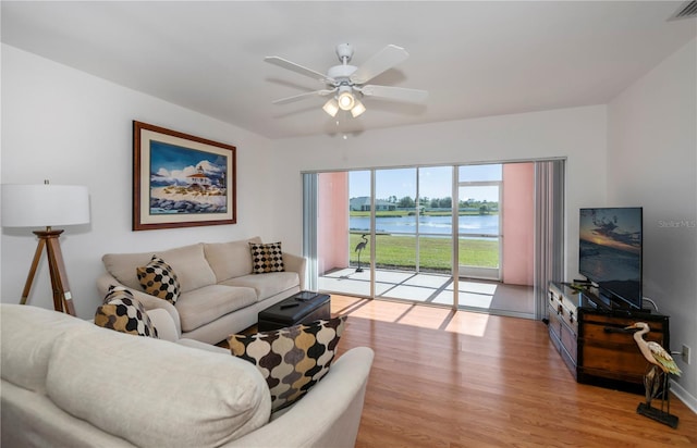 living room featuring ceiling fan and light hardwood / wood-style flooring