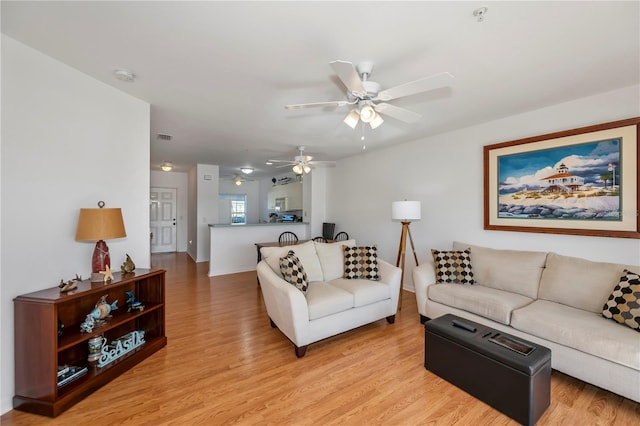 living room featuring light hardwood / wood-style floors and ceiling fan