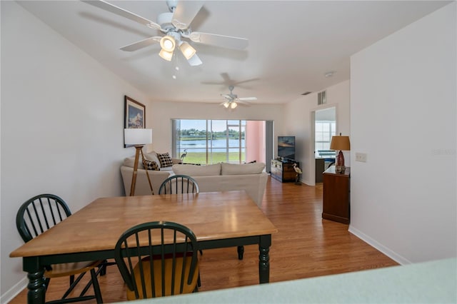 dining room with ceiling fan and light wood-type flooring