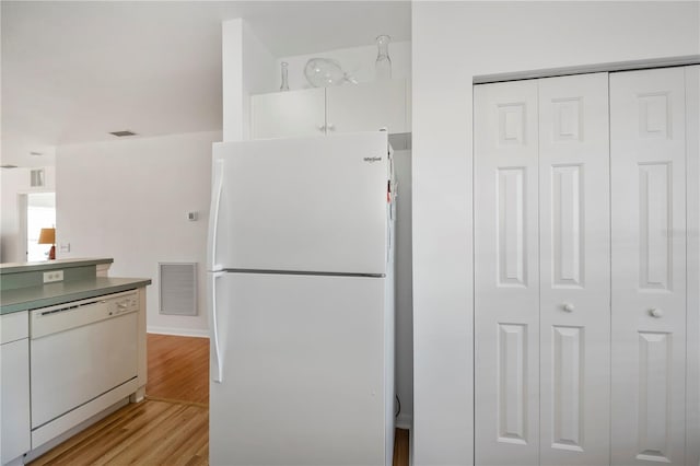 kitchen featuring white cabinets, light hardwood / wood-style floors, and white appliances