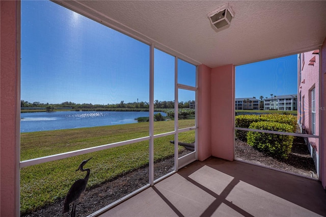 unfurnished sunroom featuring a water view