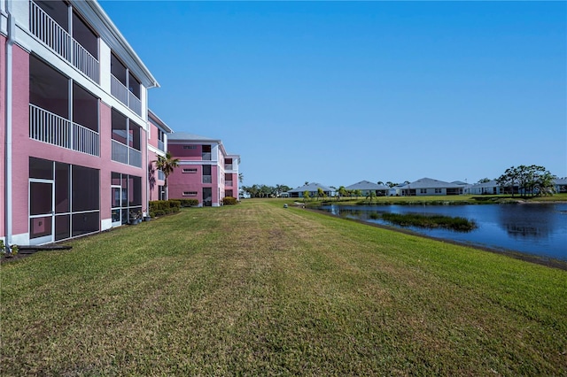 view of community with a yard and a water view