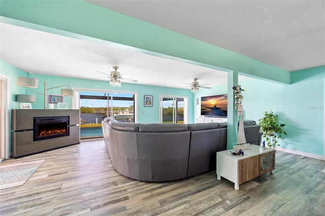 living room with hardwood / wood-style floors, a textured ceiling, and ceiling fan