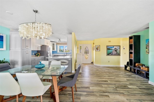 dining space featuring light hardwood / wood-style floors and an inviting chandelier