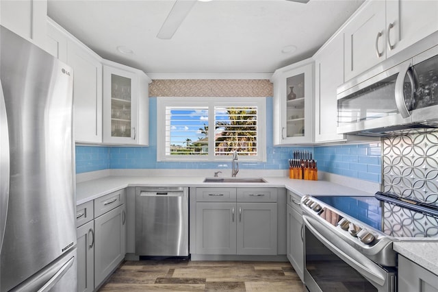 kitchen with gray cabinetry, sink, dark wood-type flooring, and appliances with stainless steel finishes