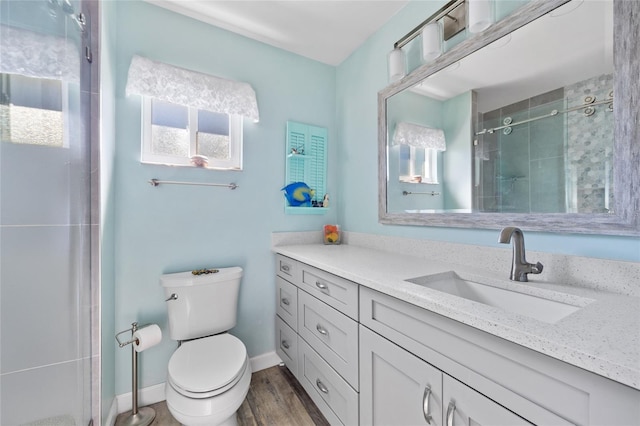 bathroom featuring hardwood / wood-style floors, vanity, toilet, and a shower with shower door