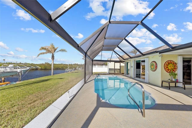 view of pool with glass enclosure, a water view, a yard, and a patio