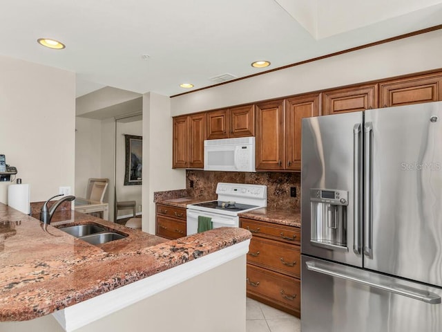 kitchen with light stone countertops, sink, tasteful backsplash, white appliances, and light tile patterned flooring