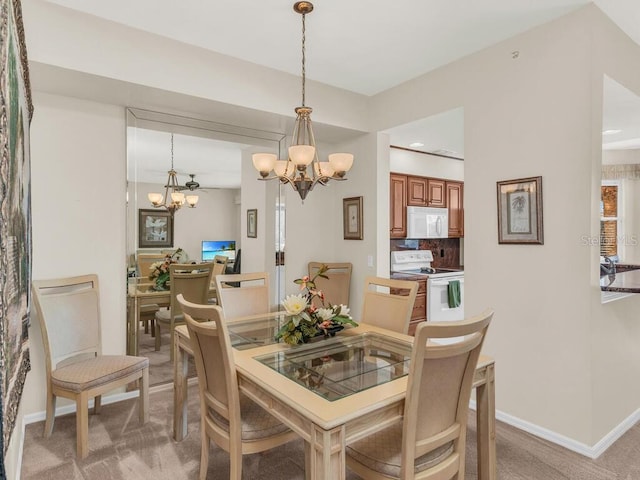 dining space with carpet and an inviting chandelier