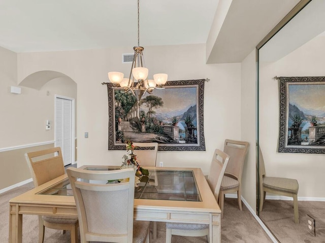 carpeted dining space featuring an inviting chandelier