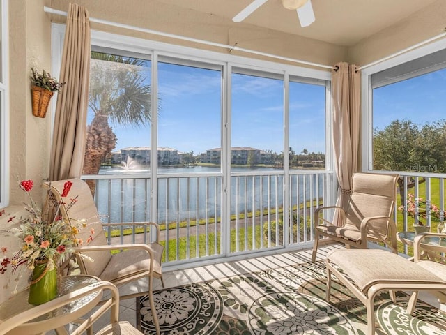 sunroom / solarium with ceiling fan and a water view