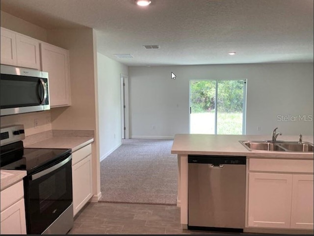 kitchen featuring sink, white cabinets, a textured ceiling, and appliances with stainless steel finishes