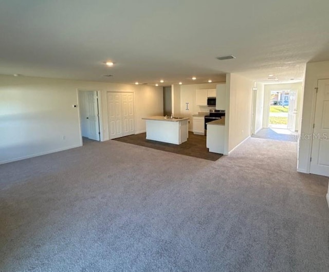 unfurnished living room with dark colored carpet