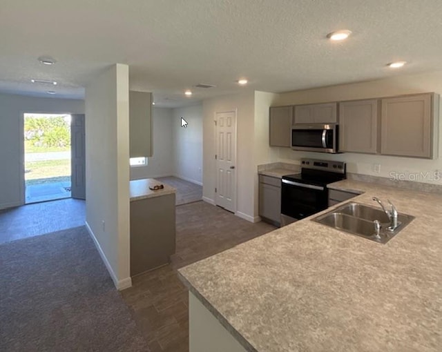 kitchen featuring gray cabinetry, sink, dark hardwood / wood-style flooring, a textured ceiling, and appliances with stainless steel finishes