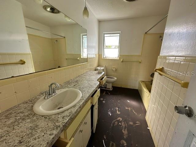 full bathroom with shower / bathing tub combination, vanity, tile walls, and toilet