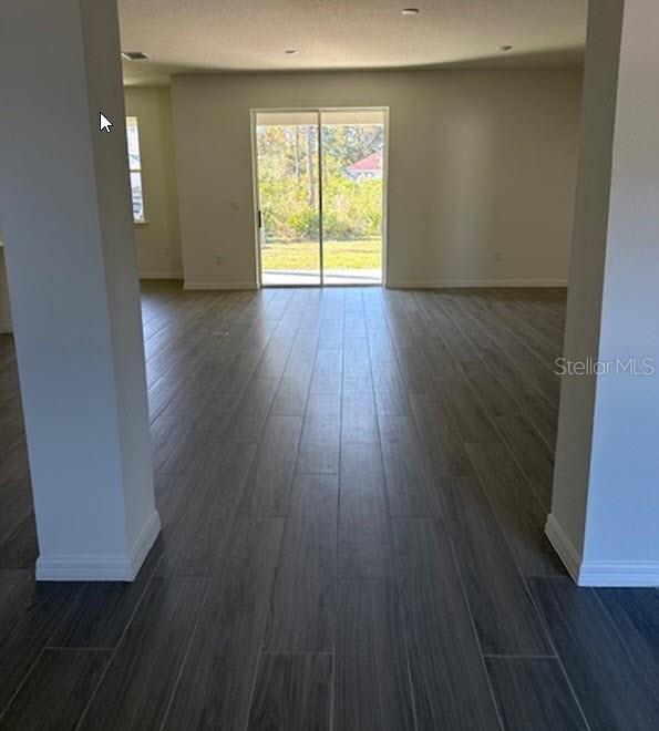 unfurnished room featuring dark wood-type flooring and a textured ceiling