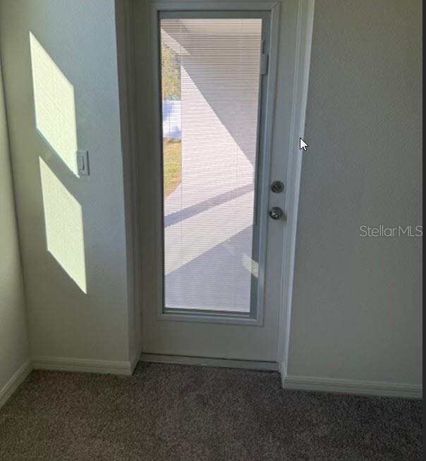 doorway to outside featuring carpet floors