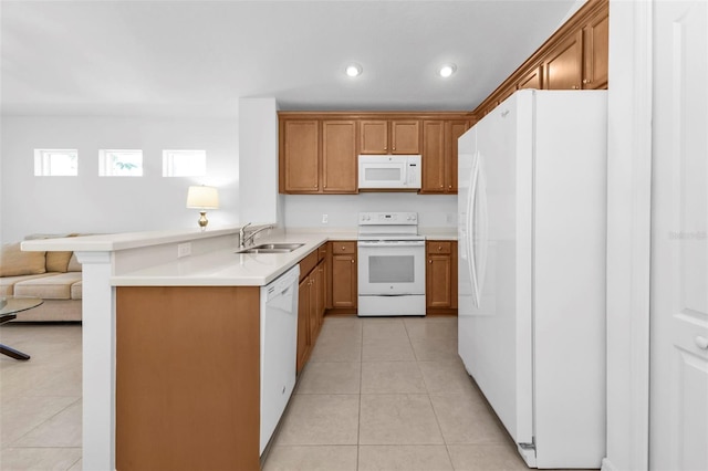 kitchen with sink, white appliances, kitchen peninsula, and light tile patterned floors