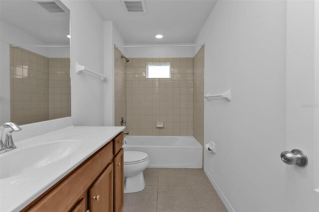 full bathroom with vanity, tile patterned flooring, tiled shower / bath, and toilet