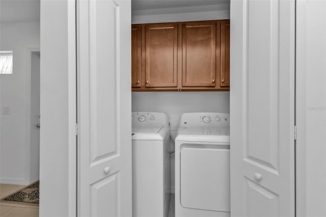 washroom with cabinets, independent washer and dryer, and light tile patterned floors