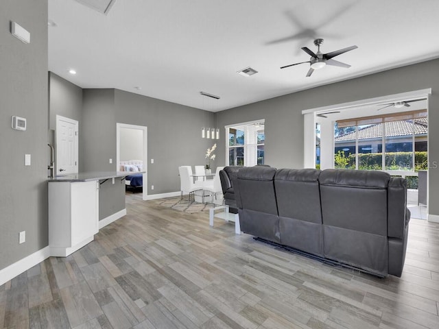 living room featuring ceiling fan and light hardwood / wood-style flooring