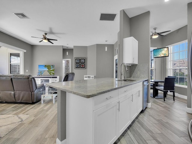 kitchen with sink, white cabinets, a healthy amount of sunlight, and light wood-type flooring