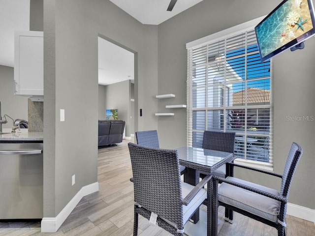 dining space featuring ceiling fan and light wood-type flooring