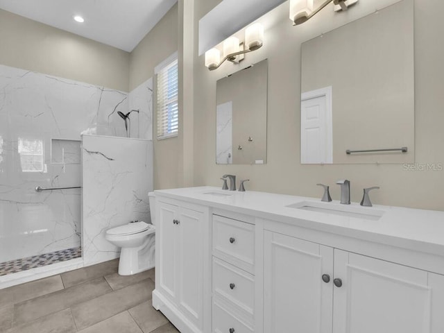 bathroom featuring tile patterned floors, vanity, toilet, and a tile shower