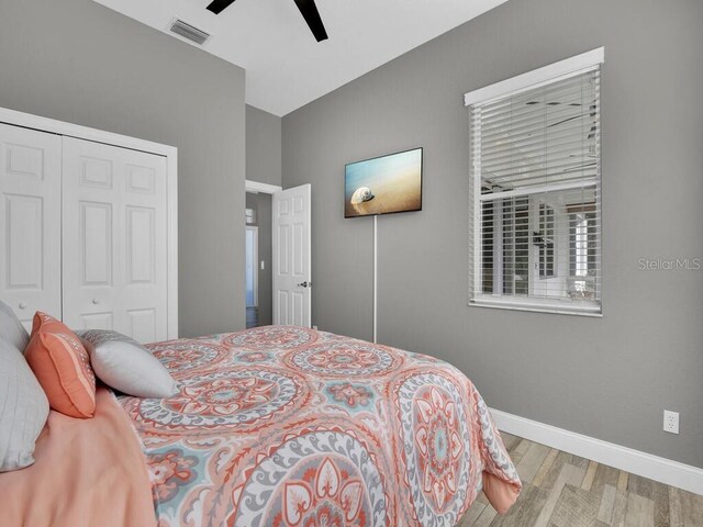 bedroom with light wood-type flooring, a closet, and ceiling fan