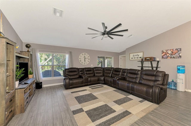 living room featuring ceiling fan, light wood-type flooring, and vaulted ceiling