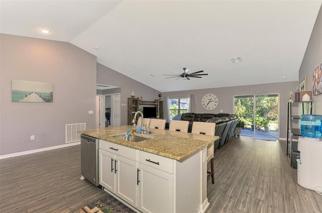 kitchen featuring lofted ceiling, sink, stainless steel dishwasher, a wealth of natural light, and white cabinetry