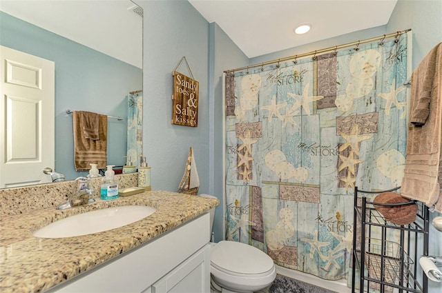 bathroom featuring walk in shower, vanity, and toilet