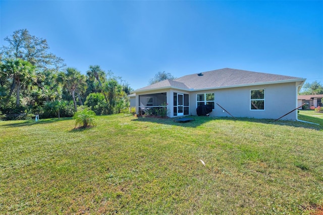 back of house featuring a yard and a sunroom