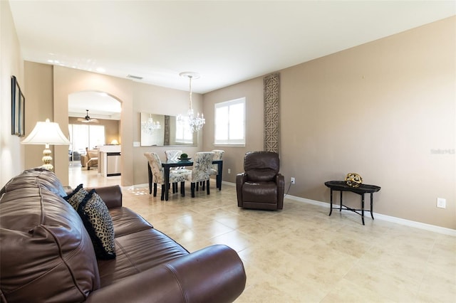 living room with light tile patterned floors and ceiling fan with notable chandelier