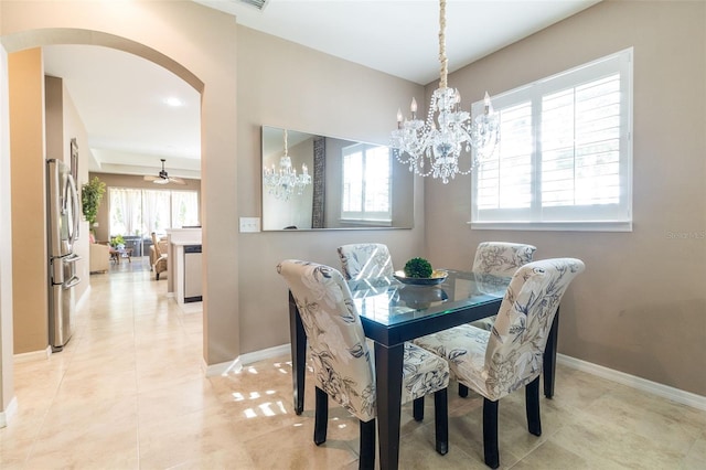 tiled dining space featuring ceiling fan with notable chandelier