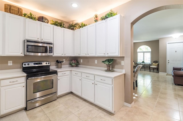 kitchen with light tile patterned floors, white cabinetry, and appliances with stainless steel finishes