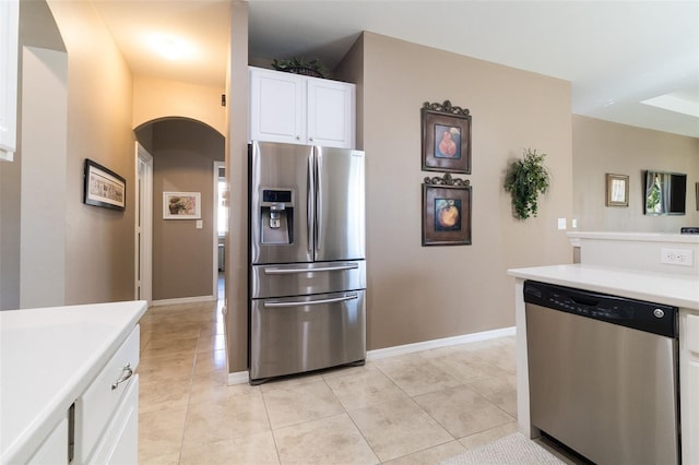 kitchen featuring light tile patterned floors, stainless steel appliances, and white cabinetry