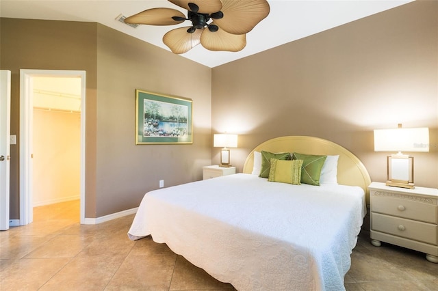 bedroom with light tile patterned floors, a walk in closet, a closet, and ceiling fan