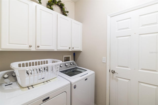 laundry area featuring washing machine and clothes dryer and cabinets