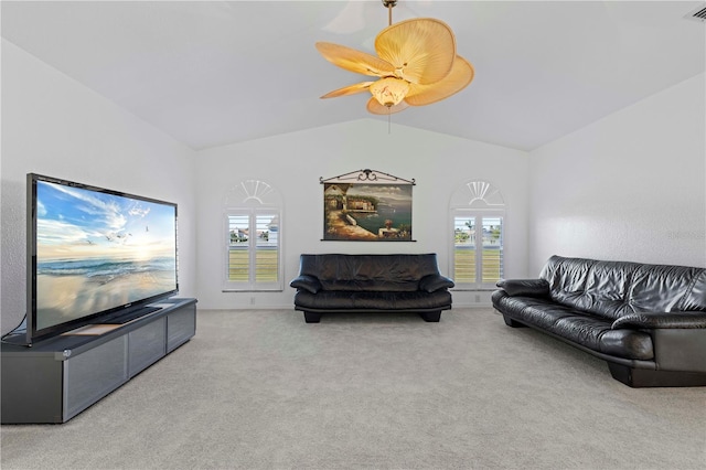 carpeted living room with ceiling fan, plenty of natural light, and vaulted ceiling